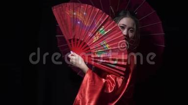 漂亮的东方女人，带着红色的扇子和<strong>一把</strong>伞，凝视着外面